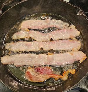 American guinea hog bacon fried in an iron skillet
