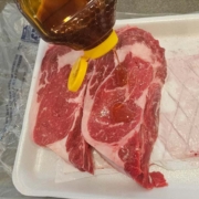 ribeye steaks getting a generous amount of local honey rubbed into them