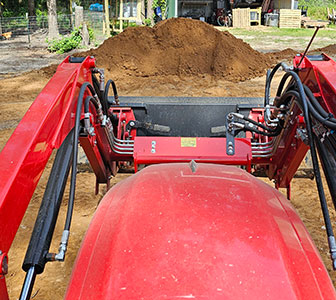 Scooping dirt with the tractor's bucket