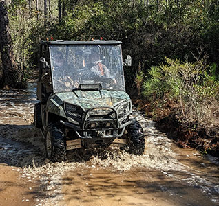 Faith driving the TnF Farms side by side through a wet area