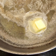 A pat of butter melting in the skillet