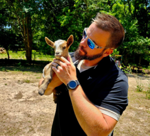 Tim with is favorite baby goat. Little Miss Frappe