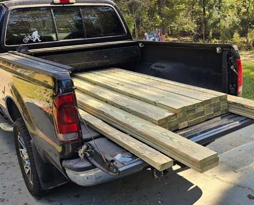 green treated lumber in the pickup bed